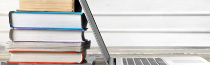 books stacked near laptop for writing articles